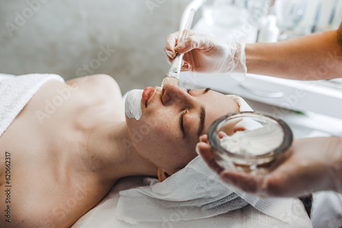 Applying moisturizing and cleansing mask on patient's face photo