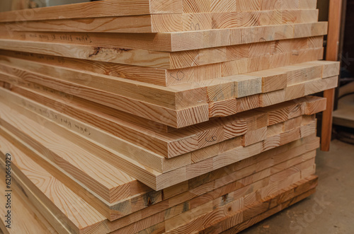 Sawn wooden boards stacked in a production workshop. Carpenter.