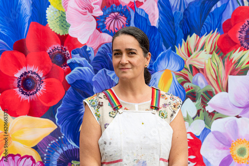 Person posing for a headshot in front of floral mural photo