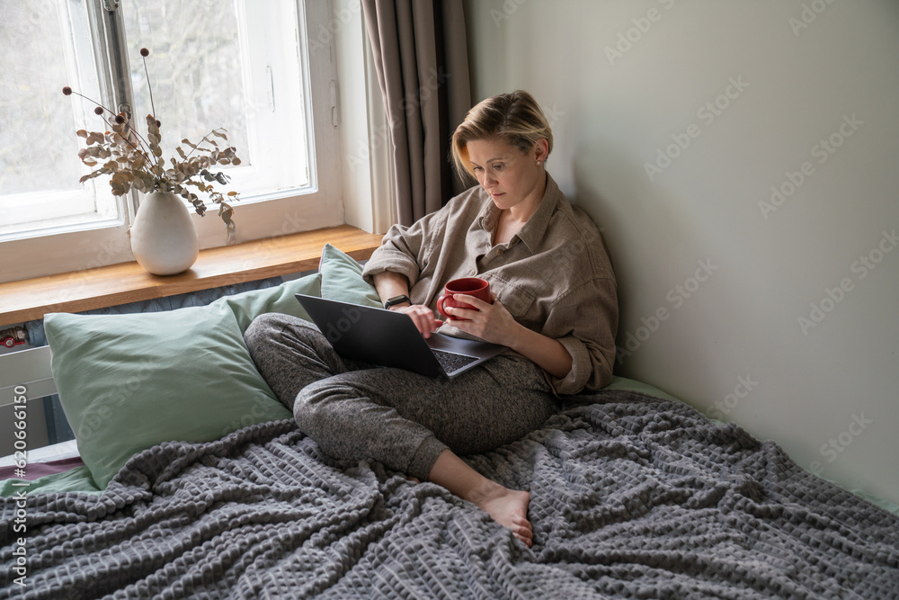 woman sitting near window on the bed woman sitting near window on the bed
