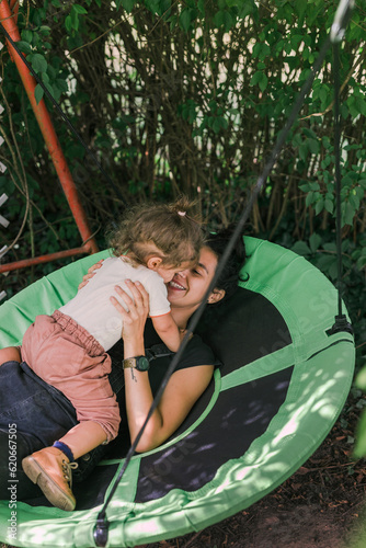 Mother and Daughter on the Round Swing in the Garden photo