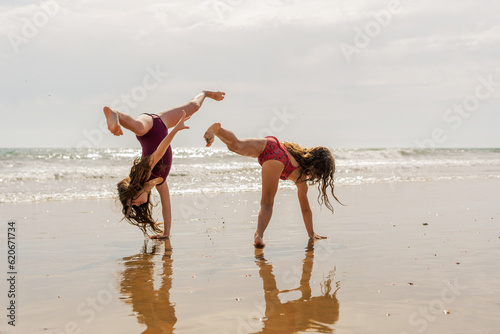 Girls doing somersaults by the seashore photo