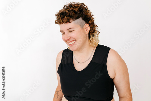 Cheerful non binary person with closed eyes in studio photo