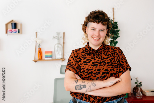 Cheerful tattooed queer with crossed arms photo