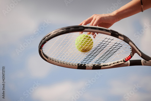 Sporty girl preparing to serve tennis ball. Close up view of beautiful girl holding tennis ball and racket © st.kolesnikov