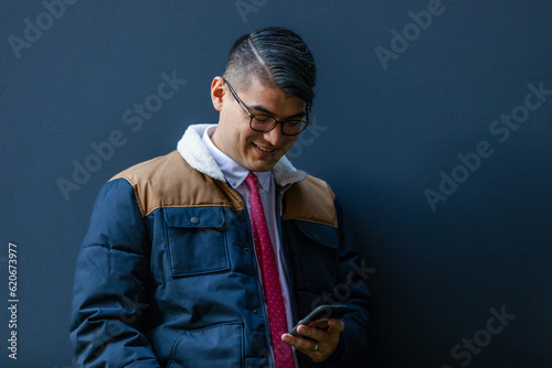 Business man with smartphone on blue wall  photo