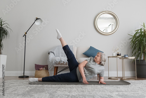 Elderly woman practicing Anantasana pose photo