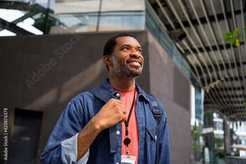 Smiling man carrying backpack in city going to office  photo