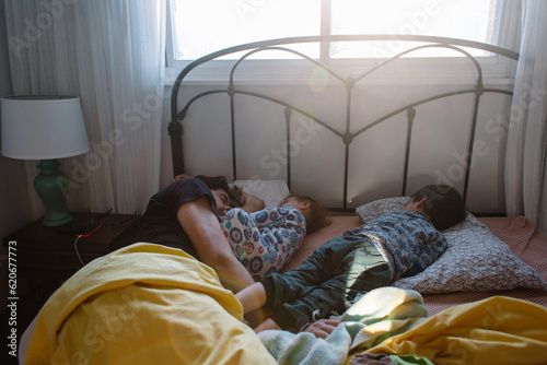 Family wakes up in early morning in bed
