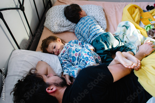 Family wakes up in early morning in bed photo