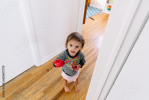 Toddler girl covered in red paint