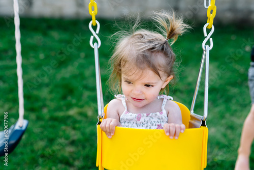 Toddler sitting in baby swing