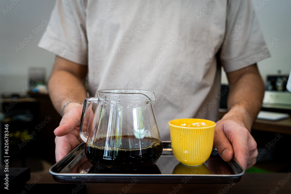 Hot coffee in glass beaker on a tray with a little yellow cup Hot coffee in glass beaker on a tray with a little yellow cup