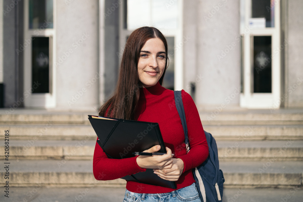 Portrait of a young student with backpack and folder outdoors Portrait of a young student with backpack and folder outdoors
