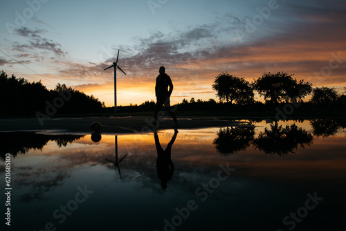 Silhouette of a man at sunset with reflection 
