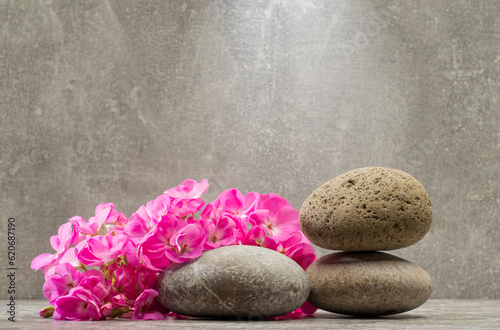 Photography gray zen stones and pink flowers on a gray background for product presentation p