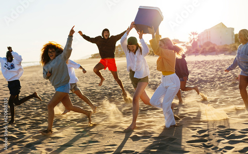 Happy friends having fun on beach in sunset