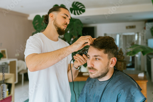 Trendy barber doing a haircut at home photo