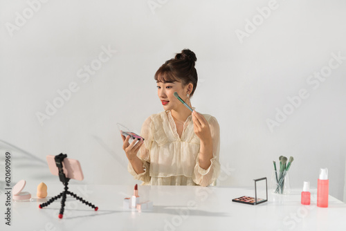 Young woman blogger making a video for her beauty blog on cosmetics. photo