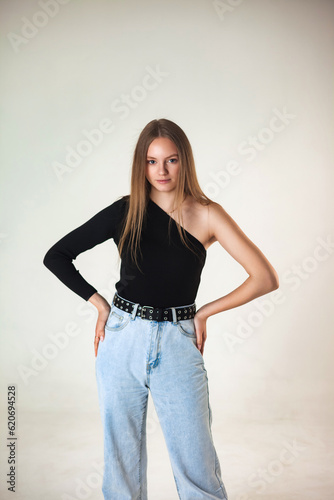 Pretty sensual cover lady in fashion denim clothes posing at white studio, looking at camera. Portrait of stylish woman model with long hair. Fashionable image style concept. Copy ad text space