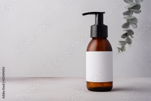 Brown glass bottle with eucalyptus for cosmetic product mock up