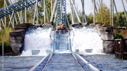 Battrupholtve, Nimtofte , Danmark - 12 26 2022: Crush down in water from water roller coaster in amusement park. Spray. Attraction. Entertainment, Boat floats on water roller coaster in amusement park photo