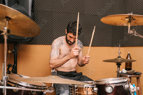 Cool bearded drummer playing drums during rehearsal photo