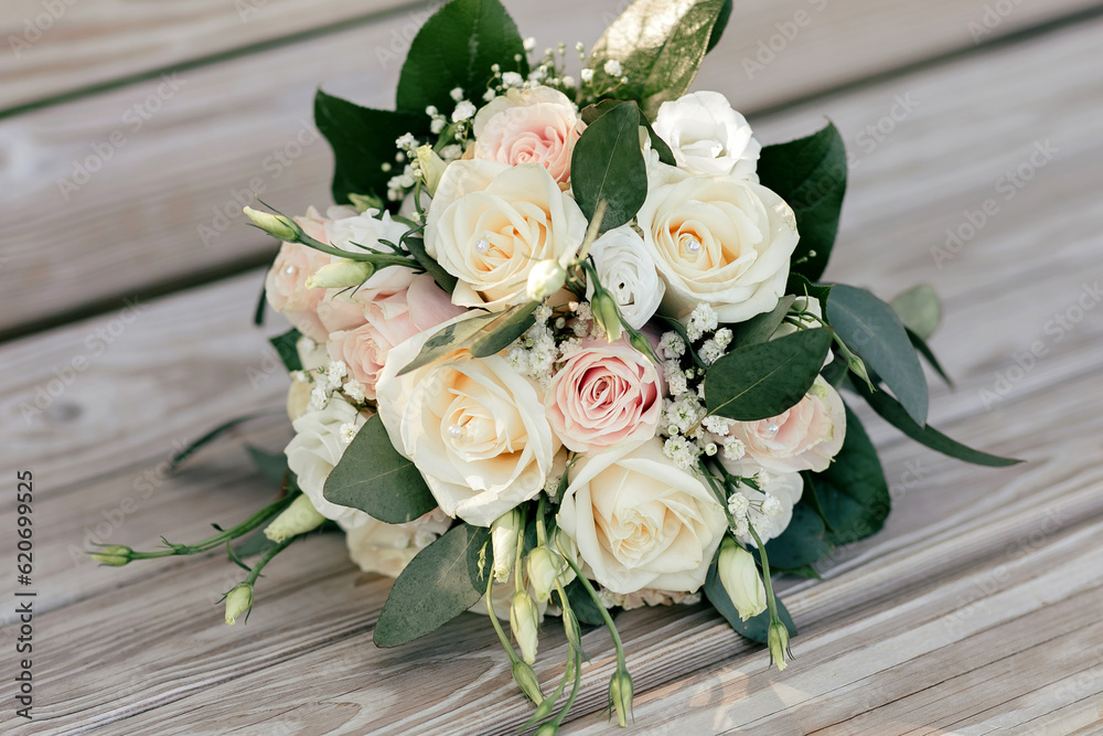 Wedding bouquet of white and pink roses on a wooden bench. Beautiful bridal bouquet of roses close-up. Traditional wedding accessory in the form of a bridal bouquet Wedding bouquet of white and pink roses on a wooden bench. Beautiful bridal bouquet of roses close-up. Traditional wedding accessory in the form of a bridal bouquet