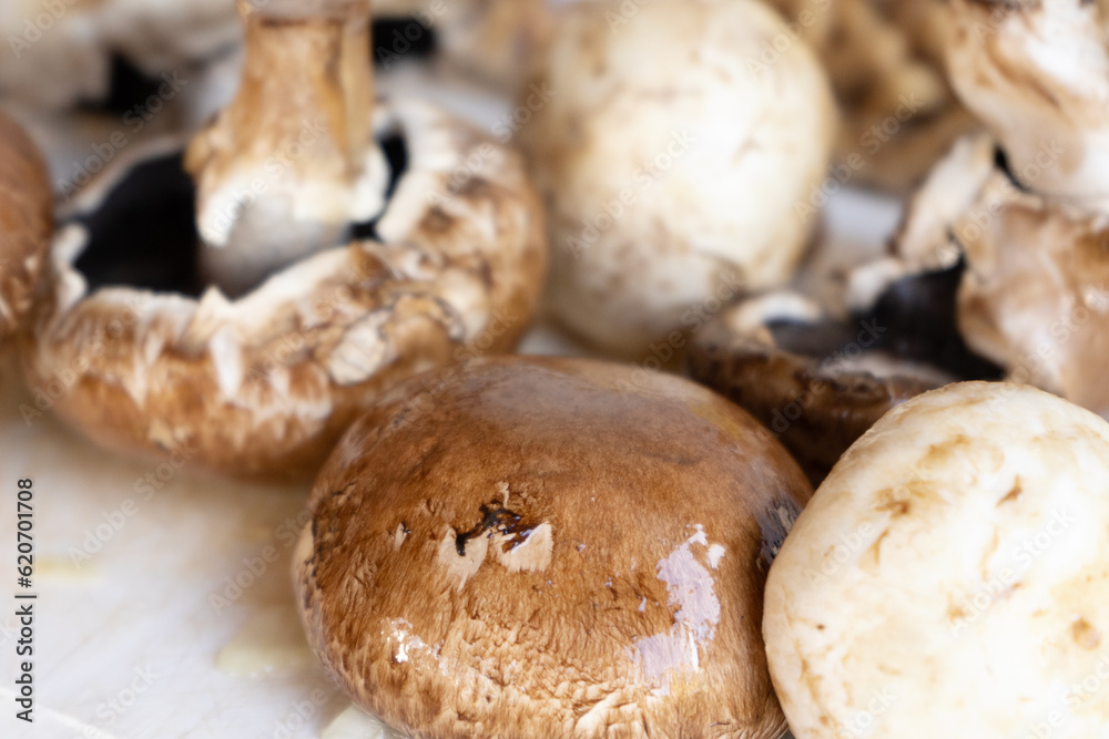 Number of mushrooms on a wooden, chopping board in a kitchen Number of mushrooms on a wooden, chopping board in a kitchen