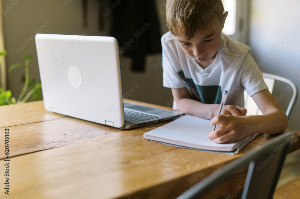 little boy doing remote school at home and writing little boy doing remote school at home and writing