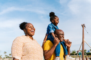 Joyful family strolling in city with playground