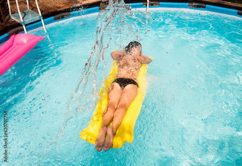 Woman floating on pool refreshed with water splash photo
