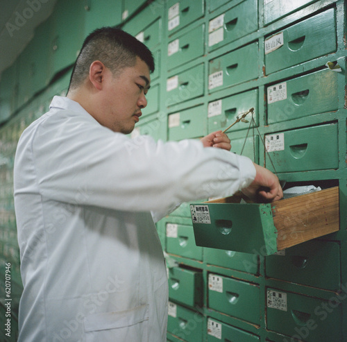 The pharmacist is weighing traditional Chinese medicine
