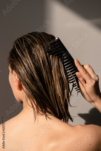 Combing wet hair with applied mask on them  photo