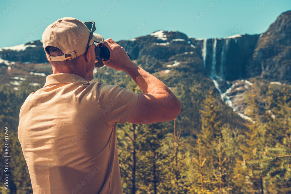 Fototapeta premium Traveler Watching Mountainscape with Binoculars