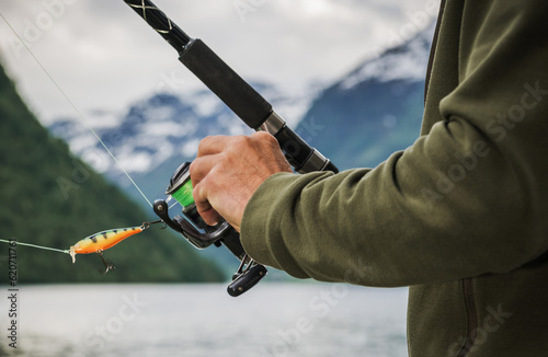 Foto Fisherman Holding Fishing Rod with Spinning Reel