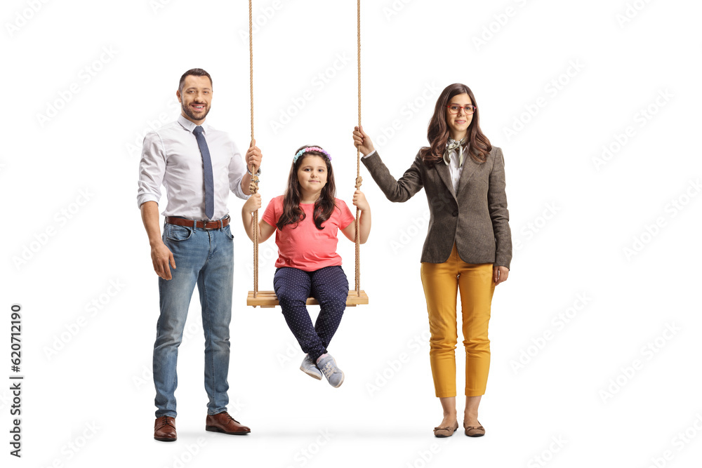 Obraz premium Girl sitting on a swing and her parents standing by her side