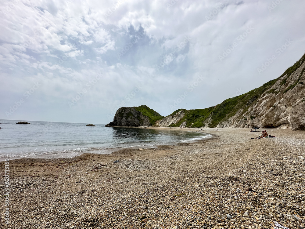 Dorset, UK. Man O'War Beach and Durdle Door on Jurassic Coast, England. Scenic bay surrounded by rocks. Beach summer holidays. Tourists and locals are enjoying beautiful landscape and sea