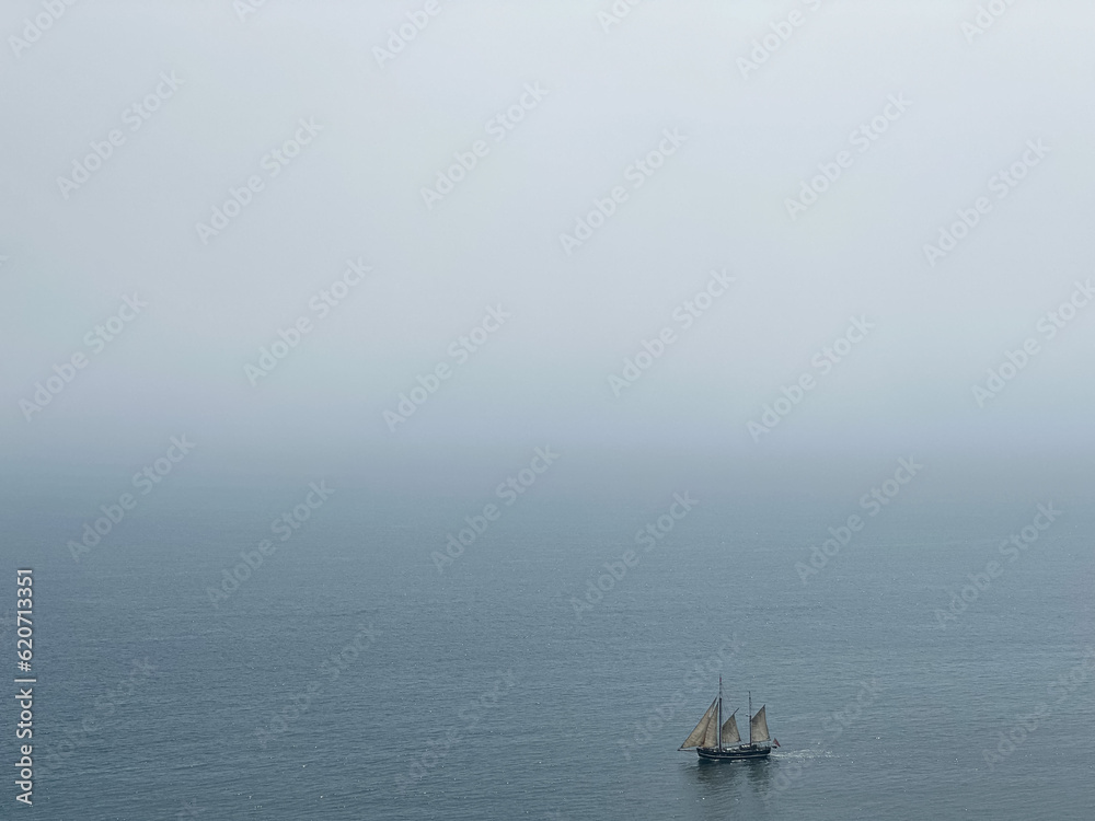 Fototapeta premium Beautiful tall ship sailing deep blue waters toward adventure along Jurassic coast in Dorset, England, UK