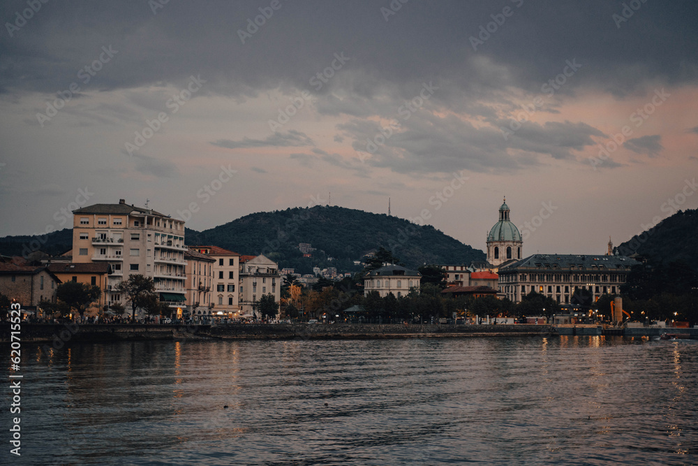 Serene sunset over Como Lake with twinkling city lights Serene sunset over Como Lake with twinkling city lights
