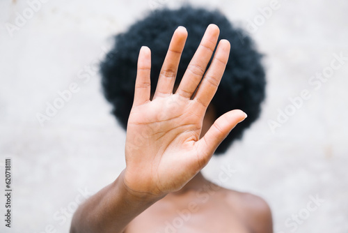 Afro girl holding hand in front of her face photo