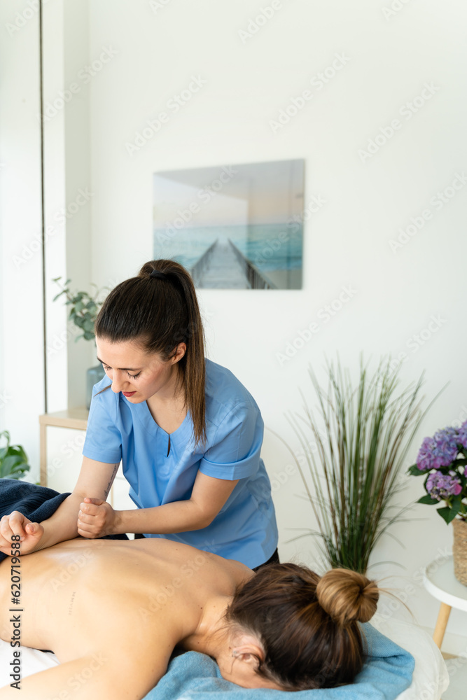 Female physical therapist giving massage to woman. Female physical therapist giving massage to woman.