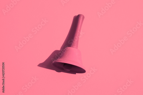 A pink bell on a pink background. Monochromatic composition photo