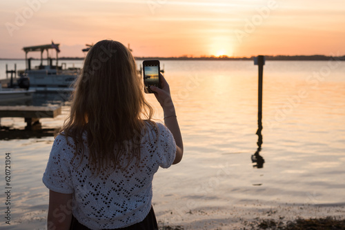 Girl taking a sunset photo
