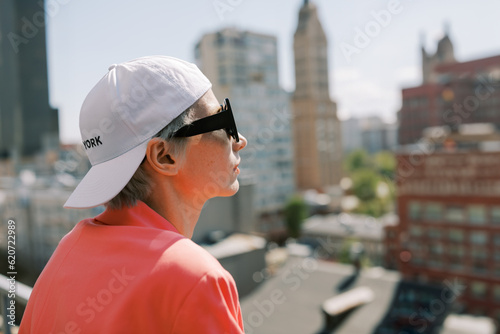woman  wearing bright pink jacket  and white cap with title NEW YORK photo