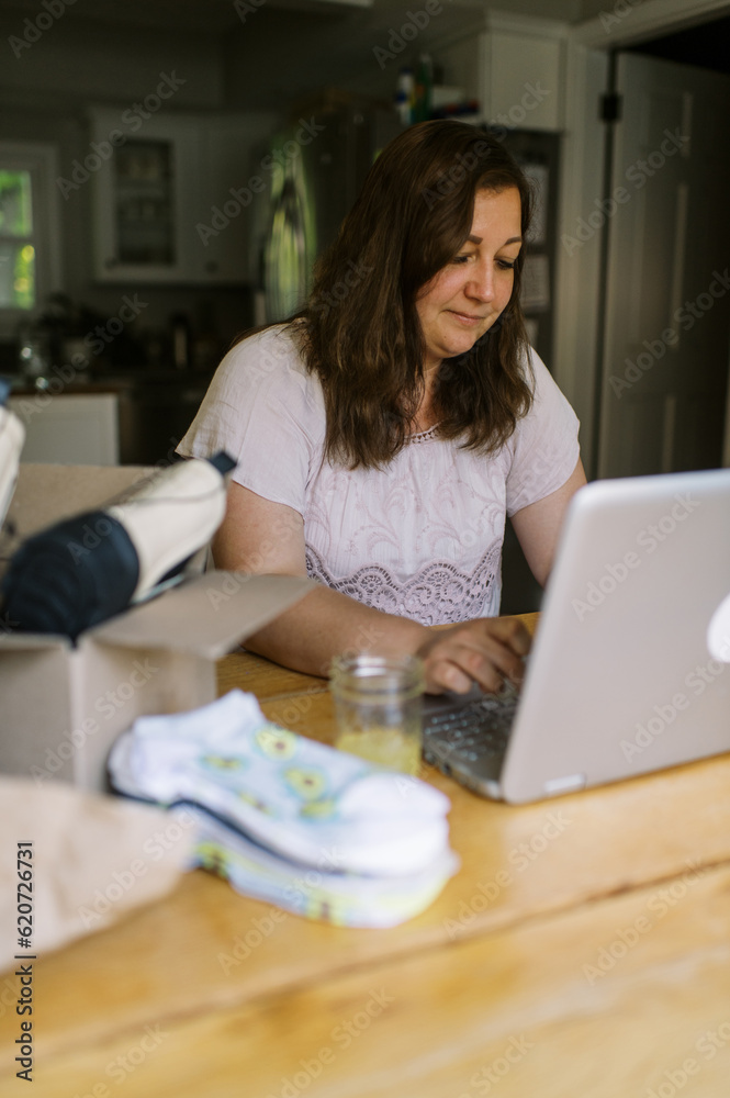 smiling online shop owner working on her computer at home smiling online shop owner working on her computer at home
