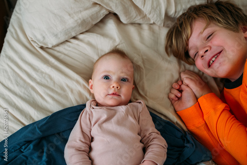 Big brother and baby on a bed