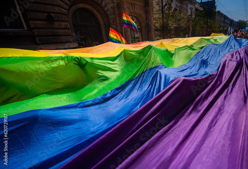 A lone hand reaches out from a huge LGBTQ flag at the Pride Parade photo