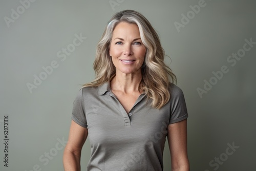 Portrait of beautiful middle-aged woman with blond hair on grey background © Eber Braun