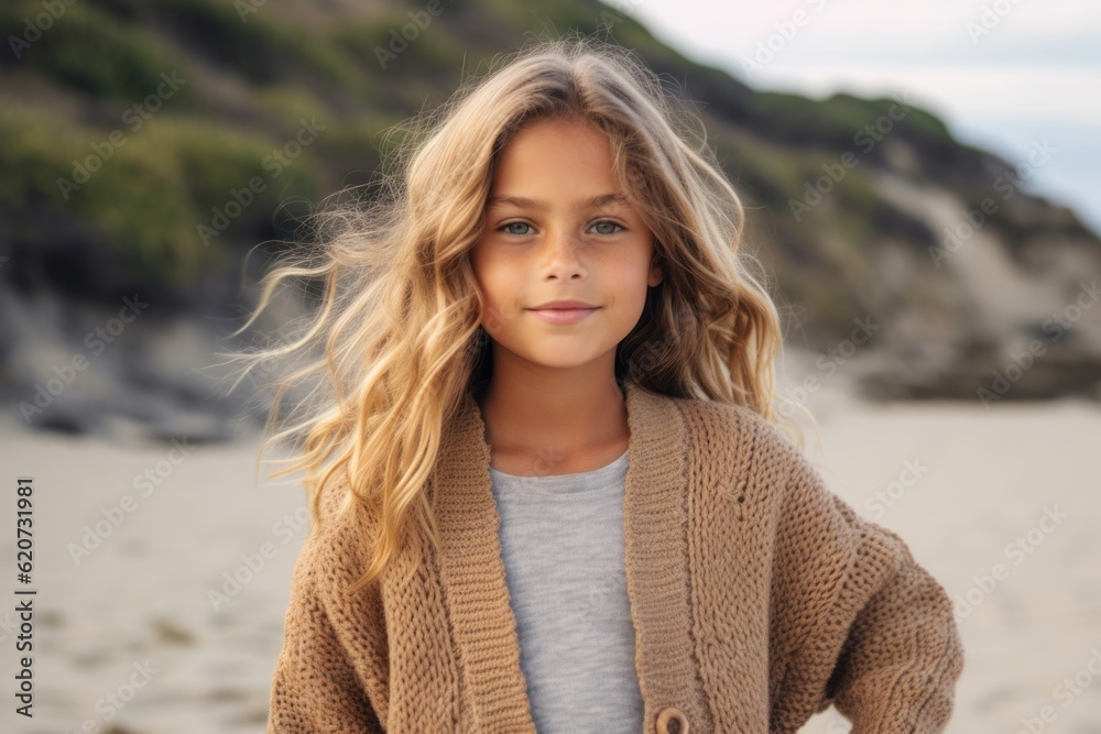 portrait of beautiful little girl with blond curly hair at the beach